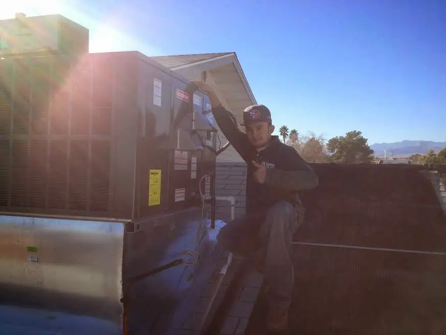 HVAC technician performing HVAC Inspection on a rooftop unit in Harpswell